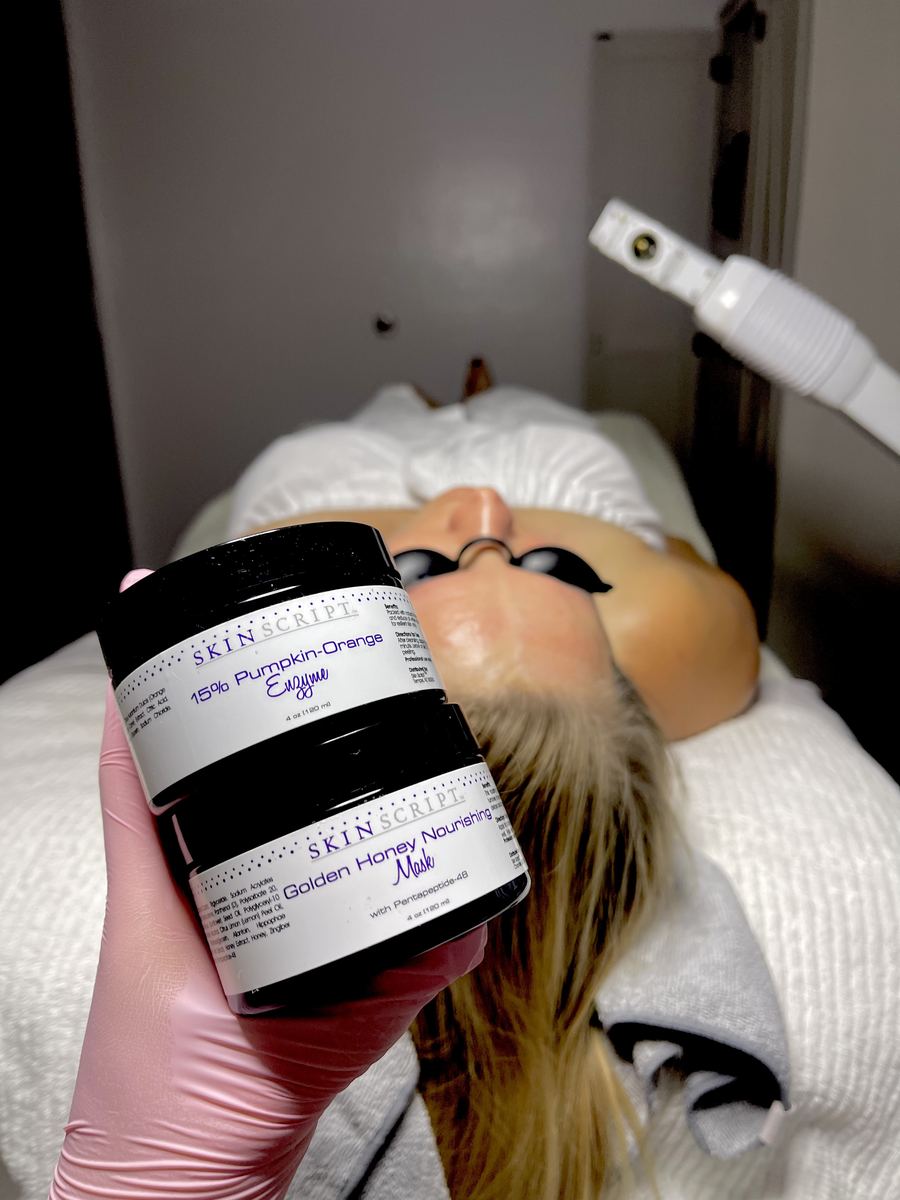 Skin Script Rx enzyme and golden honey masks held beside a client during a facial