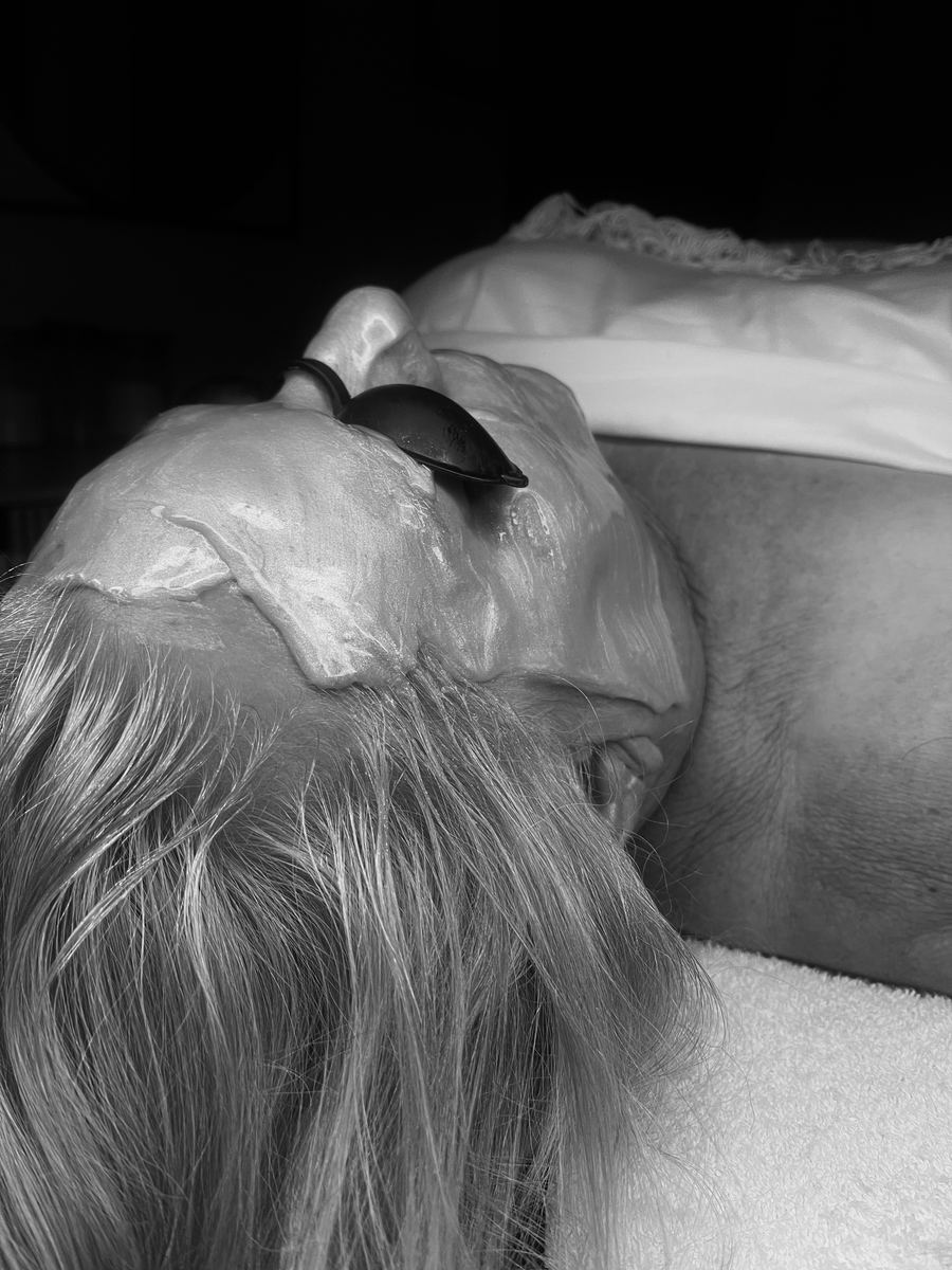 Black and white photo of a client with a facial mask on