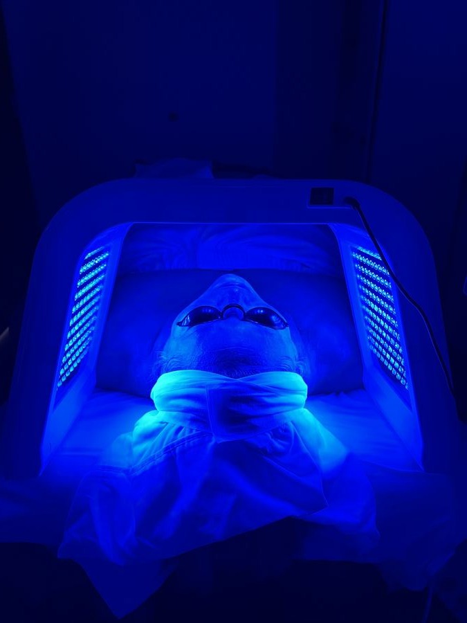 Client under blue light during a facial treatment